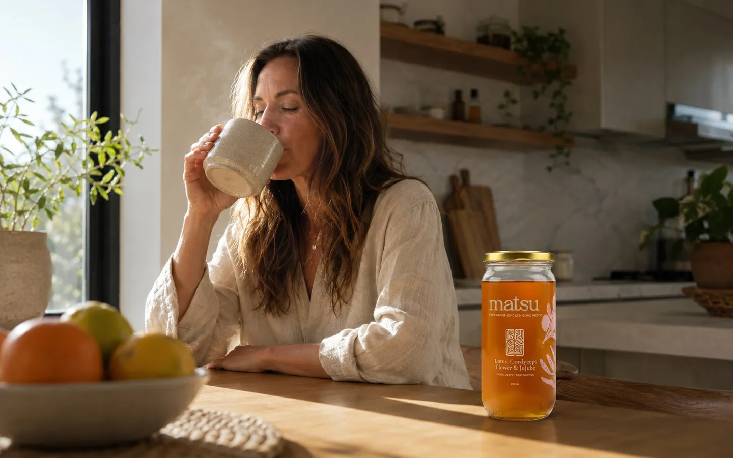 Collagen, Skin and Ageing: What Bone Broth Actually Does | Matsu A woman sipping a warm mug of bone broth in morning light beside a jar of Matsu Chicken, Lotus, Cordyceps Flower & Jujube broth